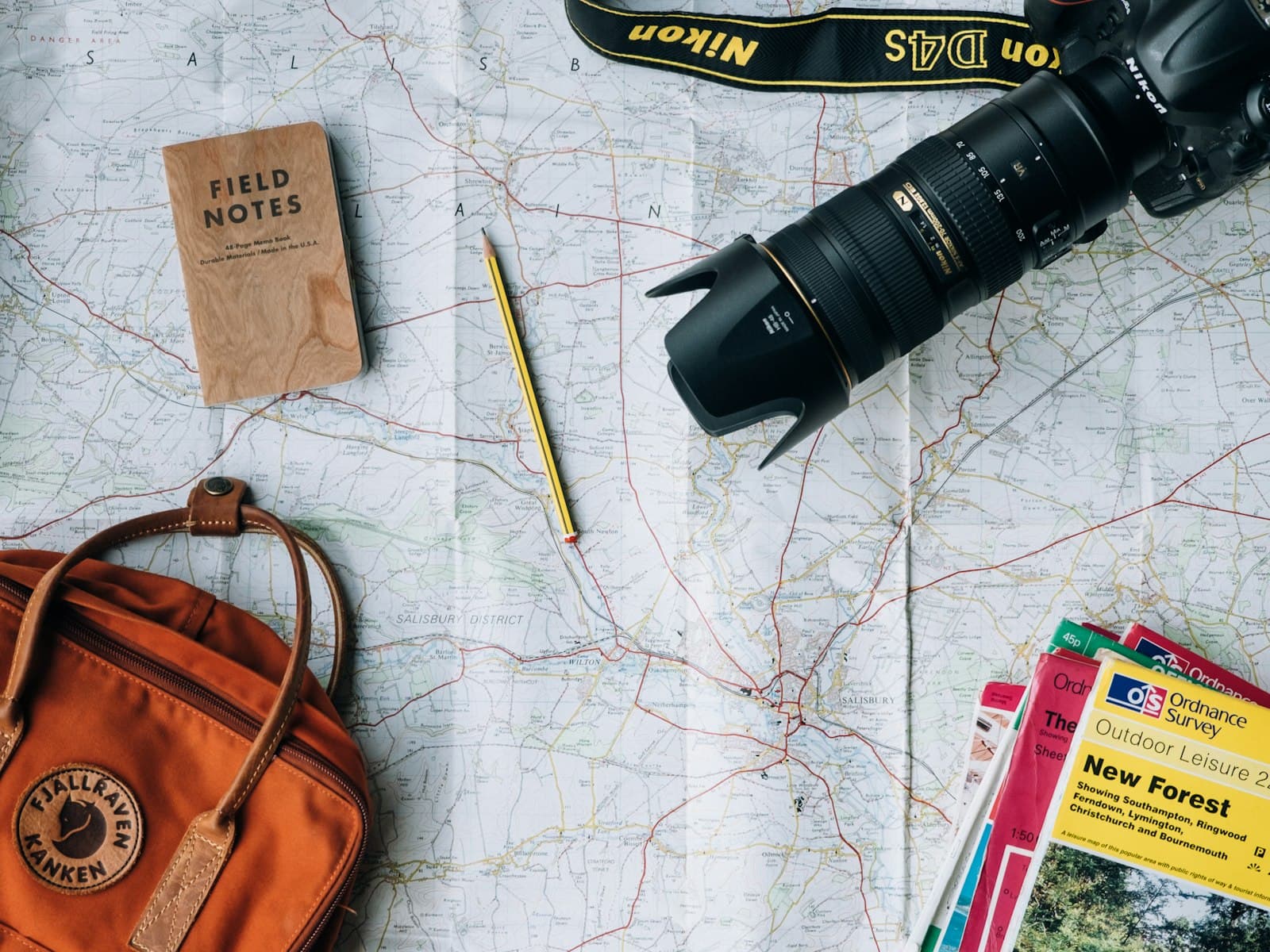 Mapa, libreta y cámara listos para planear un viaje