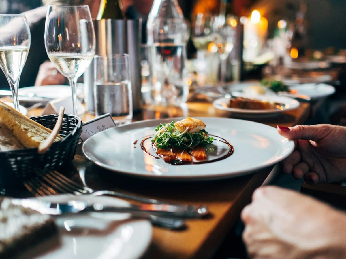 Mesa de cena elegante con platos gourmet
